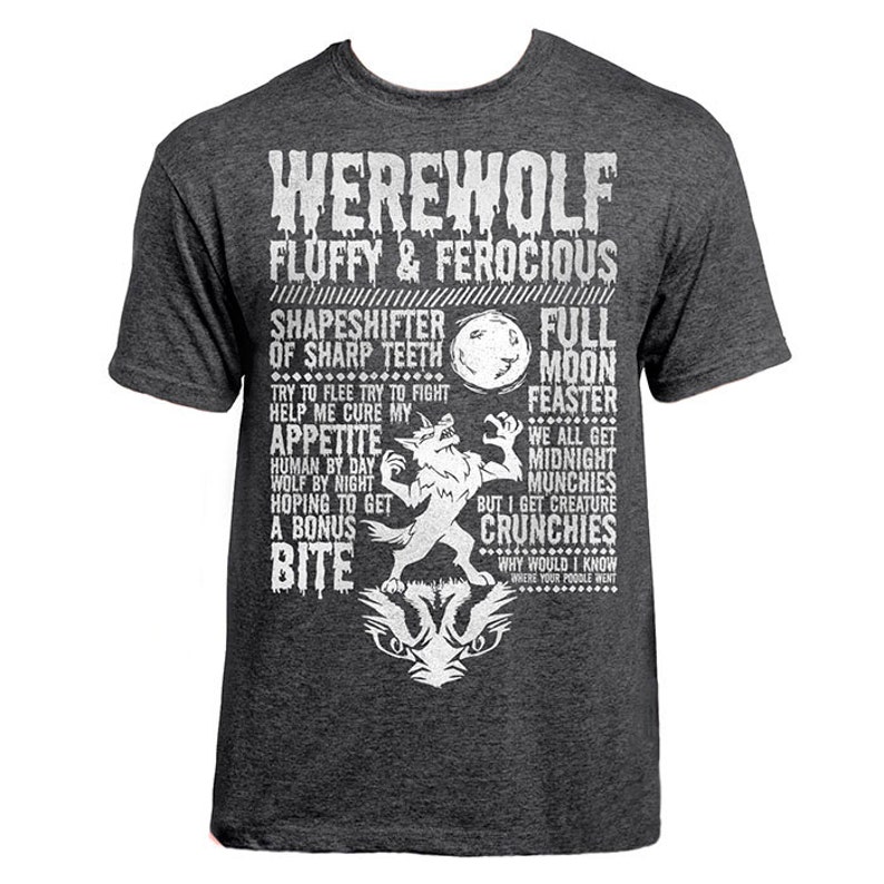 May include: A dark gray t-shirt with a white graphic design featuring a werewolf with the text "Werewolf Fluffy & Ferocious". The graphic includes the text "Shapeshifter of Sharp Teeth", "Full Moon Feaster", "Appetite", "Human by Day Wolf by Night", "Hoping to Get a Bonus Bite", "We All Get Midnight Munchies", "But I Get Creature Crunchies", and "Why Would I Know Where Your Poodle Went".
