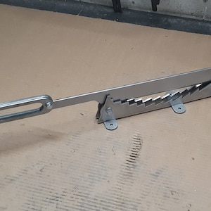 May include: A silver metal tool with a handle and a series of teeth. The tool is designed to crimp or cut something.