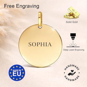 Puede incluir: Un colgante redondo de color dorado con el nombre "SOPHIA" grabado. El colgante tiene un lazo en la parte superior para una cadena. La imagen tambi&eacute;n incluye el texto "Free Engraving", "Solid Gold" y "Deep Laser Engraving".