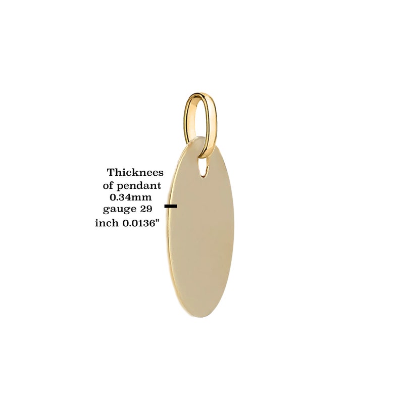 Puede incluir: Un colgante ovalado de color dorado con un peque&ntilde;o lazo en la parte superior para una cadena. El grosor del colgante es de 0,34 mm y el calibre es 29. El texto de la imagen dice: Grosor del colgante 0,34 mm calibre 29 pulgada 0,0136".