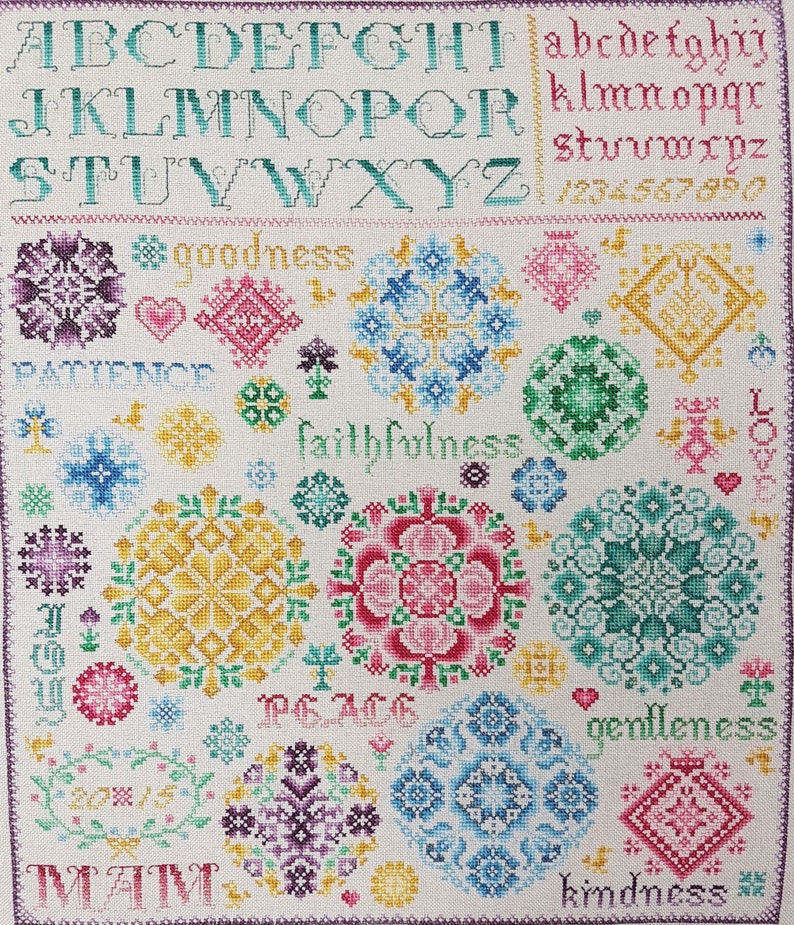 May include: Cross stitch pattern with a white background and colourful floral designs. The pattern includes the alphabet, numbers, and words like "goodness", "faithfulness", "peace", "gentleness", and "kindness".