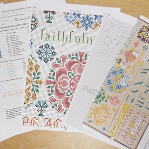 May include: A cross stitch pattern with instructions and a colour key. The pattern includes a floral design with the word "Faithful" in the centre. The pattern is printed on white paper.