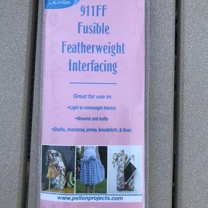 May include: A package of Pellon 911FF Fusible Featherweight Interfacing. The pink package features the brand name and product details, including the text "Great for use in: Light to midweight fabrics, Wovens and knits, Challis, chambray, jersey, broadcloth, & linen." The package is 20" x 1 yd.