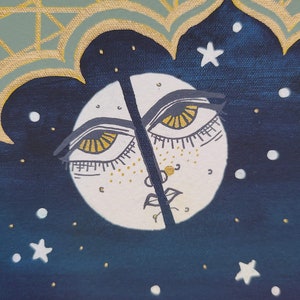Pode incluir: Uma lua branca com um rosto e dois olhos com &iacute;ris douradas sobre um fundo azul escuro com estrelas brancas. A lua &eacute; dividida ao meio por uma linha preta.