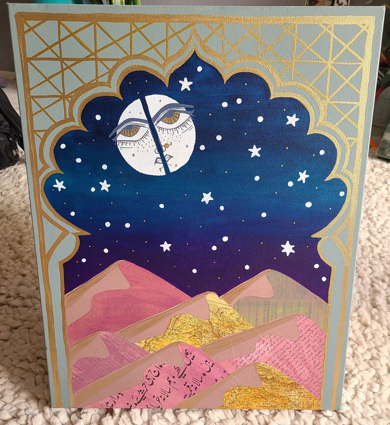 Pode incluir: Uma pintura de uma lua crescente com um rosto, contra um c&eacute;u noturno azul escuro salpicado de estrelas brancas. A lua est&aacute; parcialmente escondida por um arco dourado, e o fundo apresenta colinas rosa e marrons com texto &aacute;rabe.