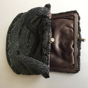 Peut inclure: Un sac &agrave; main de soir&eacute;e noir en perles avec une doublure en satin et un fermoir argent&eacute;.