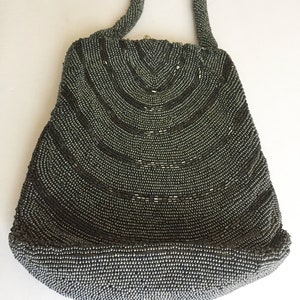 Peut inclure: Un sac &agrave; main de soir&eacute;e gris perl&eacute; avec un design incurv&eacute; et une seule anse sup&eacute;rieure.