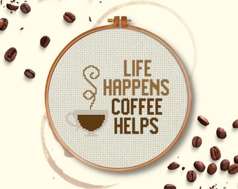 May include: A white embroidery hoop with brown embroidery floss depicting a coffee cup with steam and the text "Life Happens Coffee Helps".