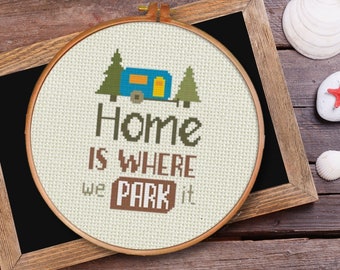 Könnte beinhalten: Ein weißer Stickrahmen mit einem Kreuzstich-Design eines blauen Wohnwagens mit dem Text "Home is where we park it".