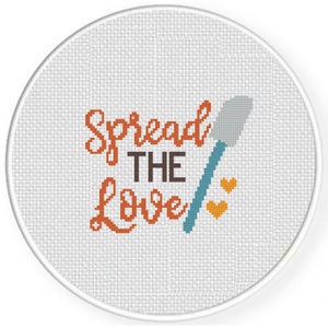 May include: A white round embroidery hoop with the text "Spread the Love" in orange and brown lettering. A blue spatula with a gray blade is shown next to the text. Two small orange hearts are shown above the spatula.