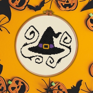 May include: A black witch's hat with a purple band and a yellow buckle, surrounded by white swirls, on a white background.