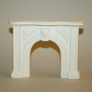 May include: White painted wooden fireplace mantel with a curved top and ornate detailing. The mantel has a large arched opening.