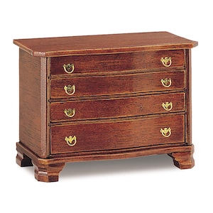 May include: A wooden chest of drawers with four drawers and brass handles. The chest is a rich mahogany colour and has a slightly curved front.