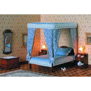 May include: A blue and white canopy bed with a white lace trim. The bed has a blue and white patterned headboard and footboard. The bed is in a room with floral wallpaper and two nightstands with lamps.