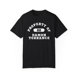 Puede incluir: Camiseta negra con texto blanco que dice "PROPERTY OF 22 DAMON TORRANCE"