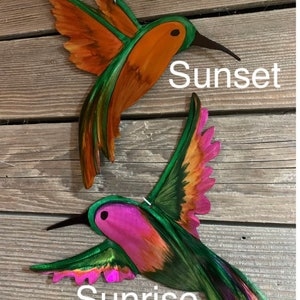 Hovering Sunset Hummingbird with blended orange and green colors. Inflight Sunrise hummingbird with pink, orange and green blended colors.