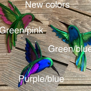 Hovering and inflight metal hummingbirds. Wall or yard art. Hand painted colors in green and pink, green and blue and purple and blue.