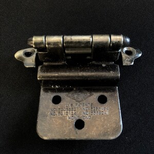 May include: A silver-toned metal hinge with a diamond-shaped logo and the text "U.S. PATENTS NO. 5205552 NO. 5285484 NO. 5212124 NO. 5588241 HONG KONG".
