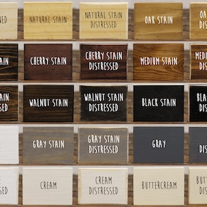 May include: A collection of 18 wood samples stained in various colors, including natural, cherry, walnut, black, gray, white, and cream. Some samples are distressed, while others are not. The samples are arranged in rows and columns on a white background.