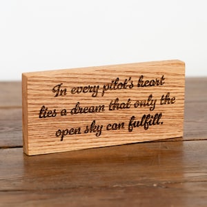 May include: A white ceramic mug with a black handle and the text "But First, Coffee" in a bold, black font. The mug is set against a blurred background, suggesting a cozy setting.