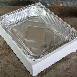 May include: A white wooden tray with a silver aluminum pan inside. The tray has four small feet on the bottom.