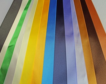 May include: A collection of 14 satin ribbon spools in various colors, including green, white, yellow, orange, blue, navy, purple, and brown.