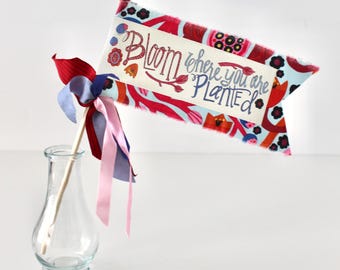 Drapeau de célébration Aimée Ferré là où vous êtes planté sur tissu rouge, orange, pervenche et fuschia à fleurs modernes