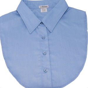 Può includere: Una camicia a collo blu chiaro con scollo arrotondato e cinque bottoni. La camicia è realizzata in 65% cotone e 35% poliestere. L'etichetta riporta "GoCollared".