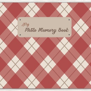 May include: A red and white plaid photo album with a brown label that says "My Photo Memory Book". The album has a brown ribbon and a tab for each month of the year.