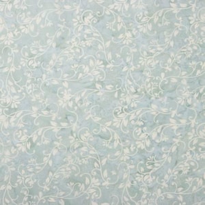 May include: A light blue background with a white floral pattern. The pattern is made up of small, delicate flowers and leaves.