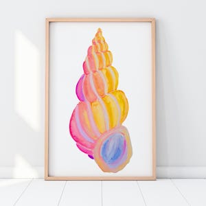 May include: A framed watercolor print of a seashell. The shell is painted in vibrant shades of pink, orange, yellow, and blue. The artwork is displayed in a light-colored wooden frame against a white background.
