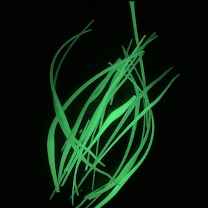May include: A cluster of thin, green, glowing lines arranged in a random pattern against a black background.