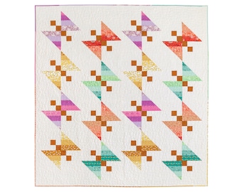 Könnte beinhalten: Eine Steppdecke mit weißem Hintergrund und einem sich wiederholenden Muster aus bunten Dreiecken mit braunen Quadraten in der Mitte. Die Dreiecke sind diagonal angeordnet.