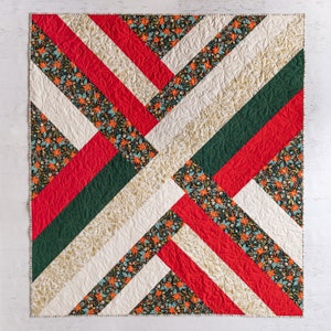 May include: A quilt with a geometric pattern of red, green, and white fabric. The fabric has a floral print.