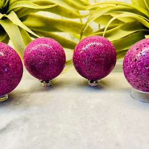 May include: Four round, purple, porous spheres on stands. The spheres have a rough, textured surface.