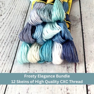 May include: A bundle of 12 skeins of high quality embroidery floss in shades of blue, white, and gray. The floss is arranged in a stack, with the colors transitioning from dark blue to light blue to white. The floss is labeled "Frosty Elegance Bundle 12 Skeins of High Quality CXC Thread".