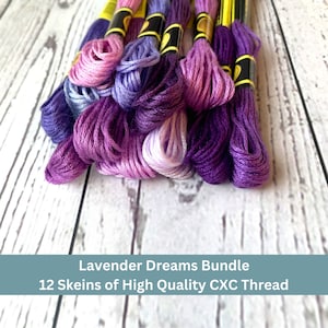 May include: A bundle of 12 skeins of high quality embroidery floss in shades of purple, lavender, and pink.  "Lavender Dreams Bundle" and "12 Skeins of High Quality CXC Thread" are printed on the label.