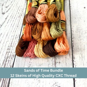 May include: A bundle of 12 skeins of high quality embroidery floss in shades of brown, orange, and peach. The skeins are labeled "Sands of Time Bundle".