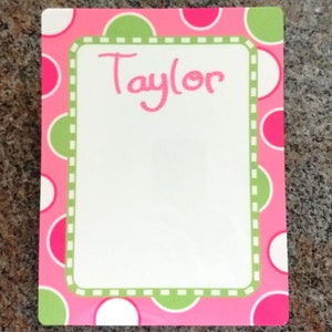 May include: Pink and green polka dot dry erase board with a white frame and the name "Taylor" written in cursive.