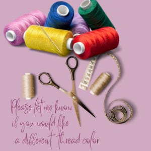 Pode incluir: Um conjunto de artigos de costura incluindo carret&eacute;is de linha nas cores rosa, azul, amarelo, roxo, verde, vermelho e bege, uma tesoura de metal e uma fita m&eacute;trica branca. O texto diz: Please let me know if you would like a different thread color.