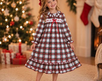 May include: A long-sleeved nightgown featuring a red, green, and white plaid pattern. The garment includes a ruffled collar, a white lace trim across the chest, a red ribbon bow at the center, and a ruffled hemline at the bottom edge.