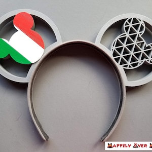 May include: Gray mouse ears headband with a green, white, and red Italian flag on one ear and a gray geometric design on the other ear.