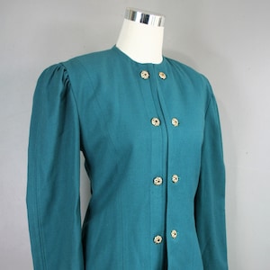 May include: Teal blazer with a button-up front and black trim on the cuffs. The blazer has gold buttons with a floral design.