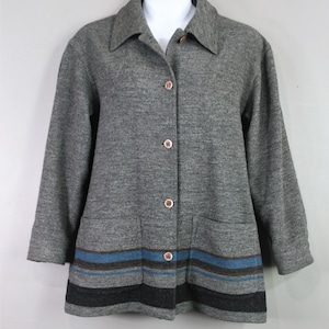 May include: A gray jacket with a collared neckline and three-quarter sleeves. The jacket has a button-up front and two front pockets. The bottom of the jacket features horizontal stripes in blue, brown, and black.