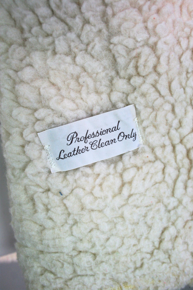 May include: White fabric with a white tag that reads "Professional Leather Clean Only".