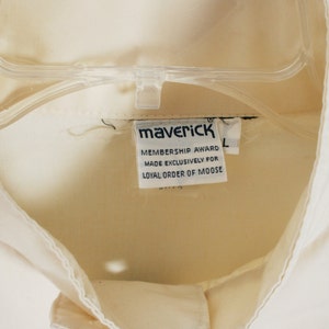 Puede incluir: Camisa blanca con una etiqueta que dice "Maverick Membership Award Made Exclusively for Loyal Order of Moose".