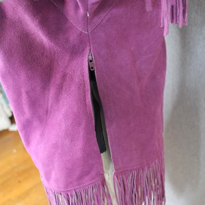 May include: Purple suede skirt with fringe trim and a zipper down the back.