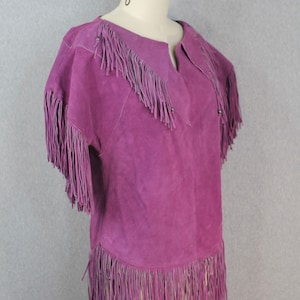 May include: Purple suede jacket with fringe detailing on the collar, sleeves, and hem.