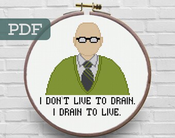 May include: A cross-stitch pattern featuring a cartoon of a bald man wearing glasses and a green sweater with a black and white striped tie. The text below the cartoon reads "I don't live to drain. I drain to live."