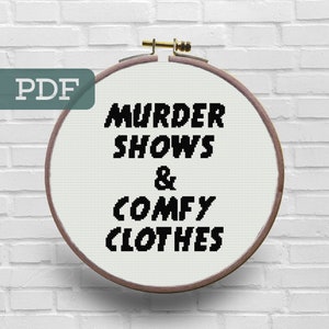 May include: A white embroidery hoop with black text that reads "Murder Shows & Comfy Clothes". The hoop is hanging on a white brick wall. The text "PDF" is in a green rectangle in the top left corner of the image.